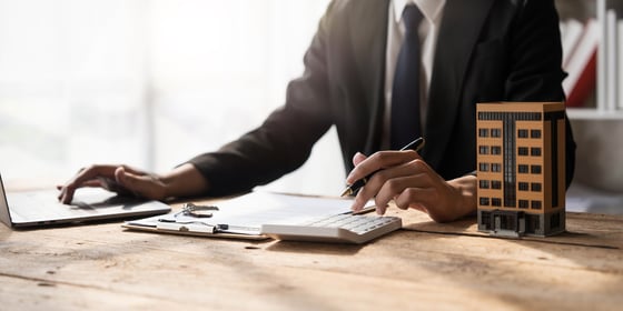 Entrepreneur working at a desk while calculating which is the best commercial business loan for him.