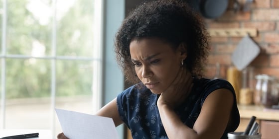 Stressed real estate investor reading letter about her loan getting denied