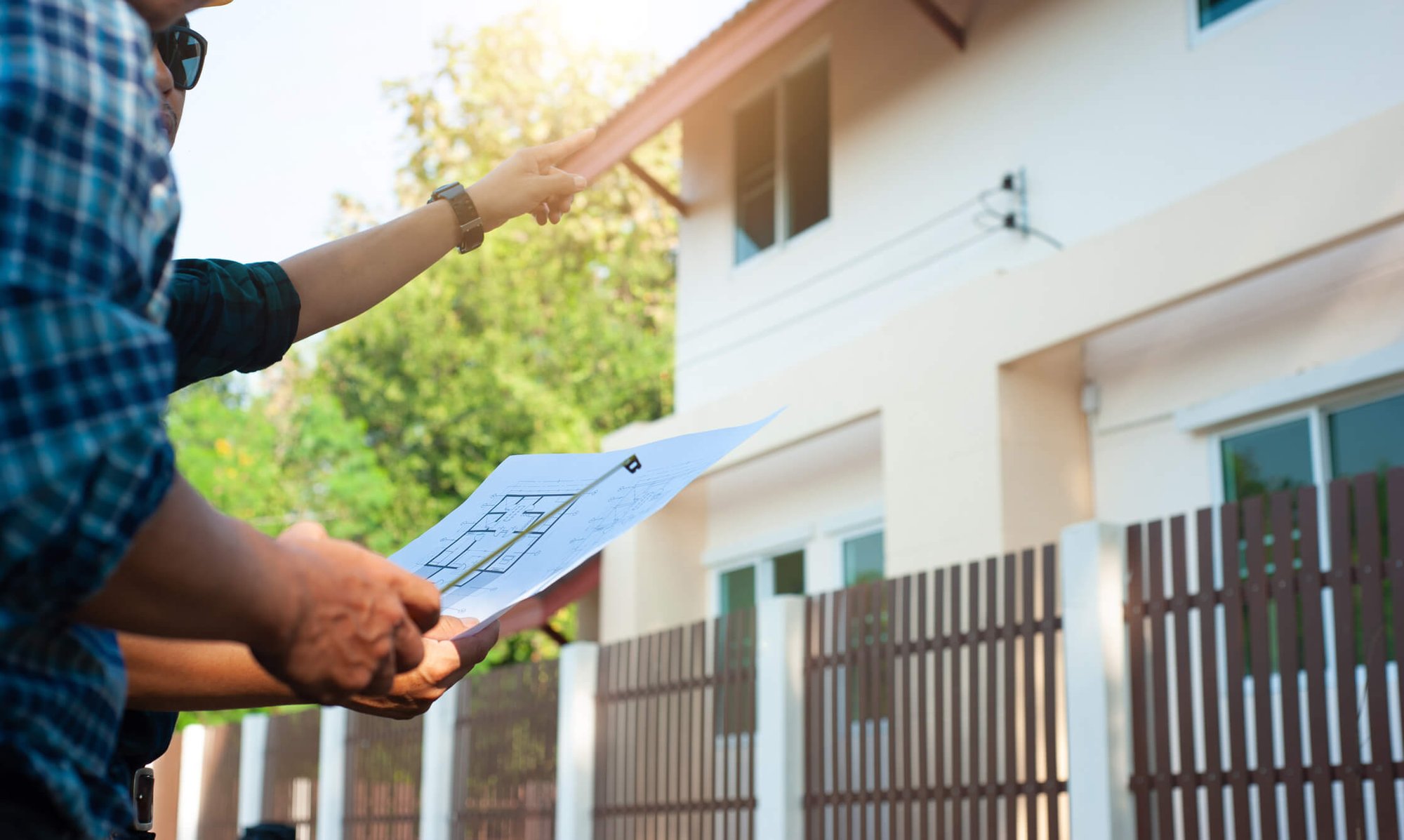 Real estate investor holding blueprints for a fix and flip property he purchased